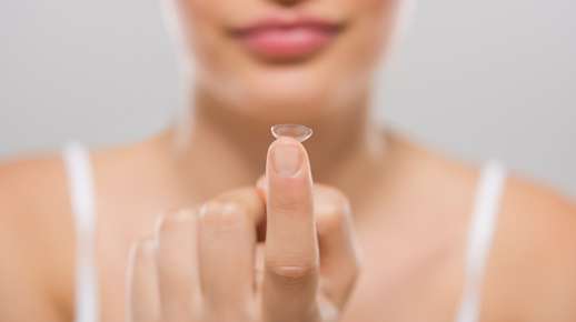 Fingertip balancing a contact lens