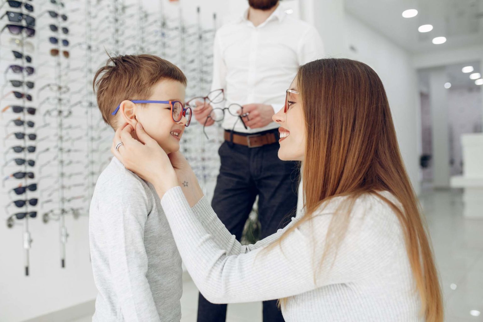 Mother with cute son. Family buy glasses. Assistant helping the clients Eyeglasses and Lenses in Minnesota and Wisconsin