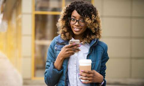 woman with glasses on holding a coffee cup