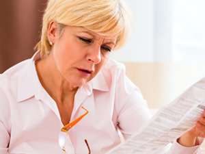 Woman trying to read paper without glasses