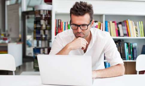 man sitting in office on a computer 