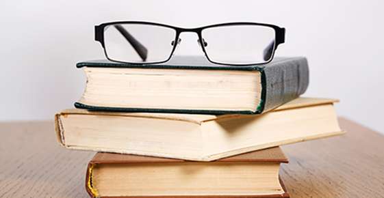 Glasses balancing on books 