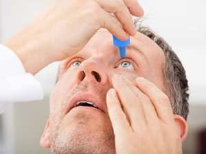 Man putting in eyedrops